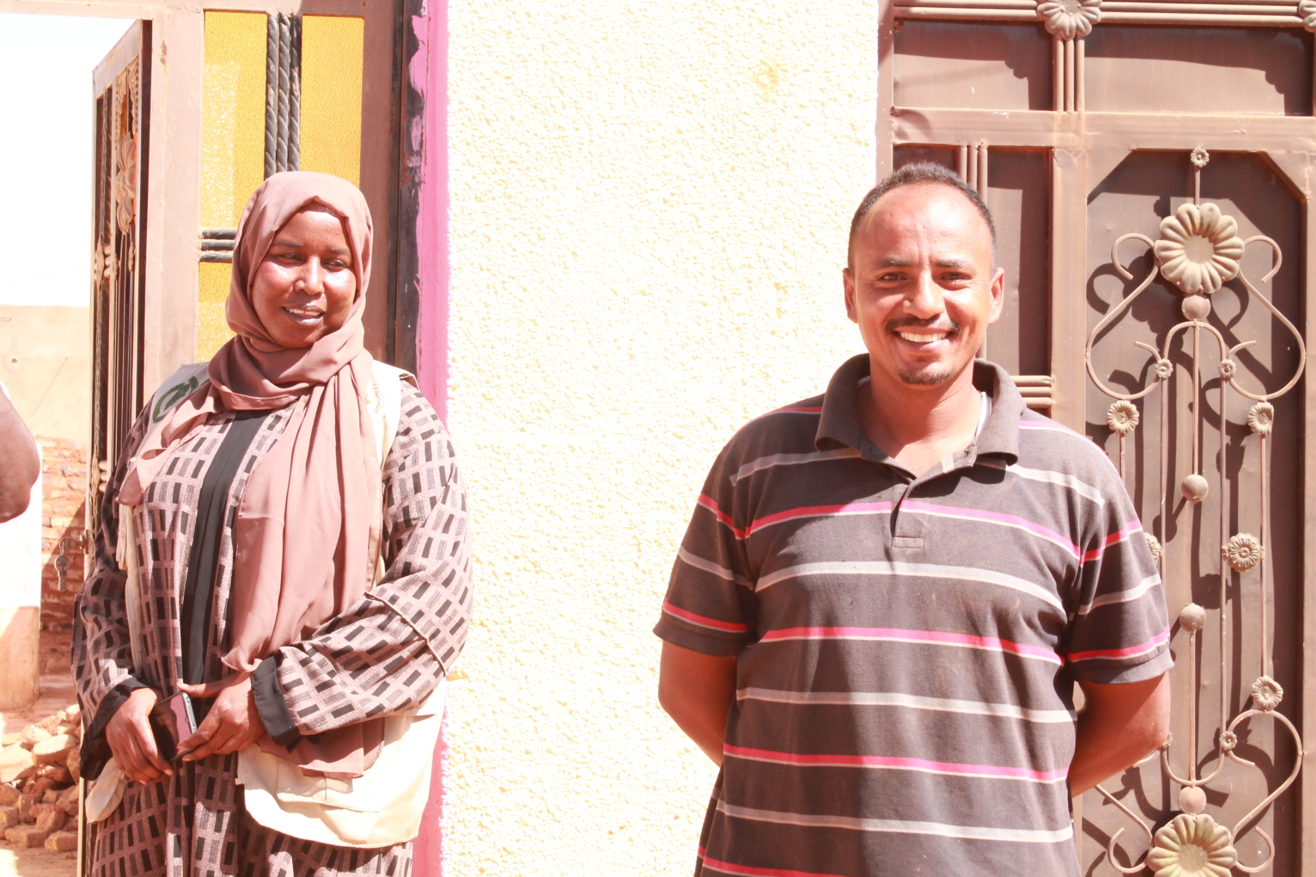 Mr. and Mrs. Ibrahim smile, relieved from the fear of explosive hazard in their yard